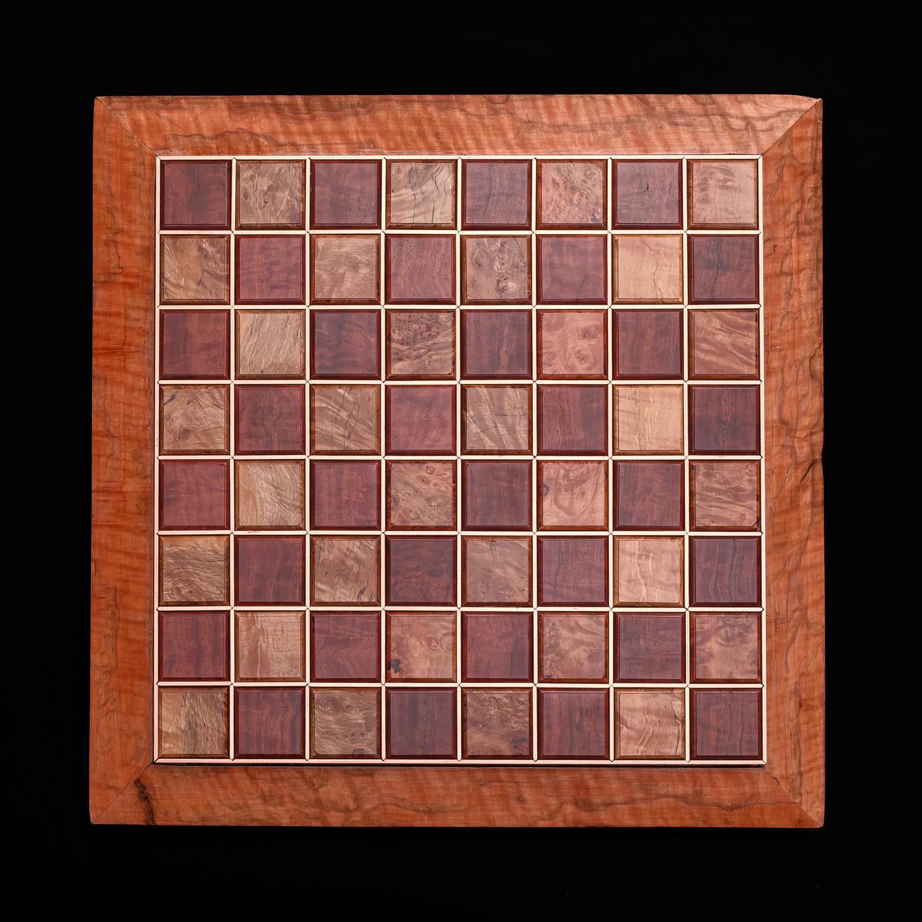 Full top-down view of a handmade chess board with a checkerboard of Jarrah and Tasmanian Rose Myrtle tiles, separated by copper lines, in a figured rose myrtle frame