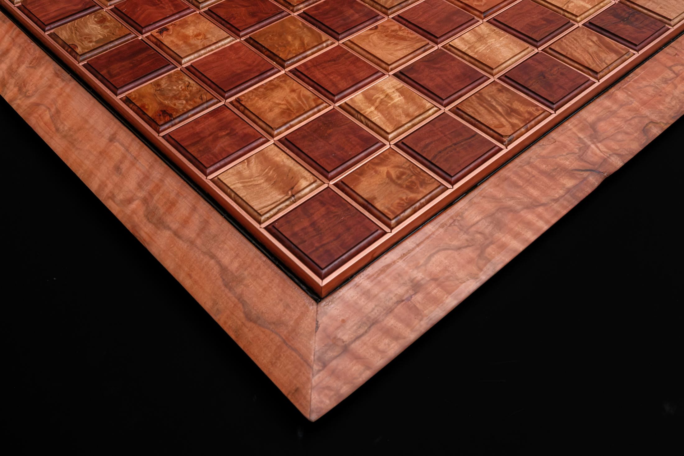 Corner detail of a handmade chess board in Jarrah and Tasmanian Rose Myrtle, bound in copper, with a figured rose myrtle frame